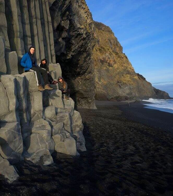 Photo de groupe assis sur les rochers près de l'océan