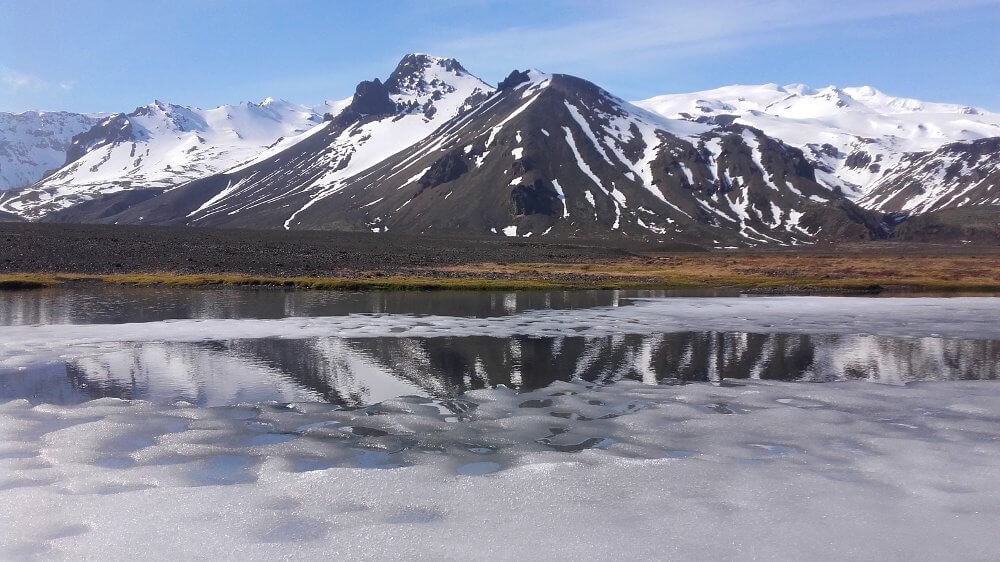 Reflets des montagnes dans un petit lac gelé